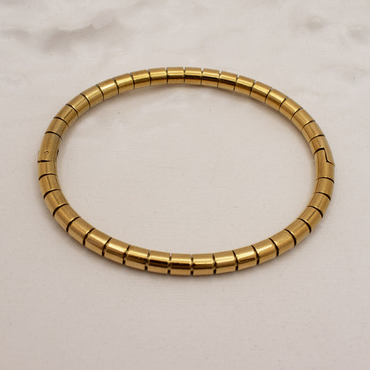 Gold bracelet on a light beige background