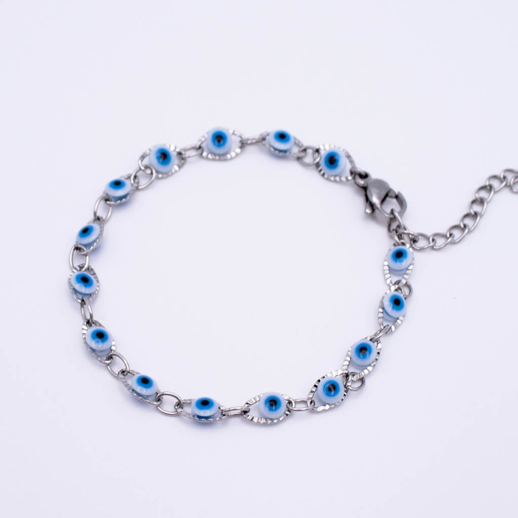 A silver chain bracelet featuring multiple evil eye charms with blue and white centers, displayed on a clean white background.
