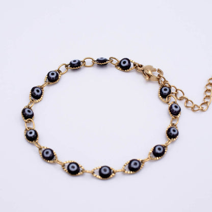 Gold chain bracelet with evil eye beads, shown on a plain white background.