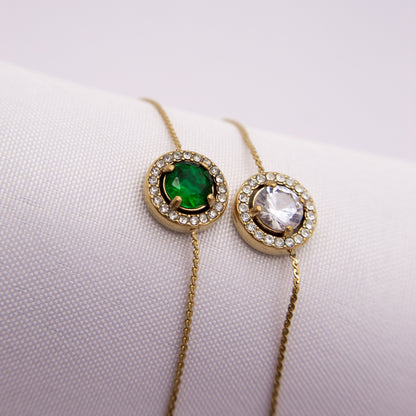 Two gold necklaces with gemstones on a white background
