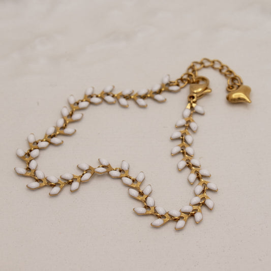 Gold and white beaded necklace on a beige background
