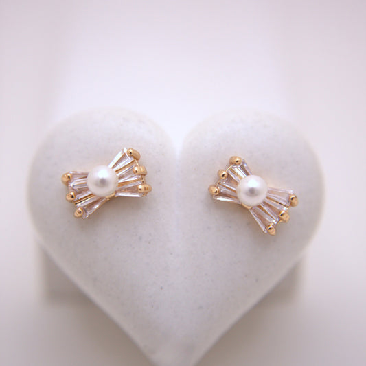 Pair of pearl earrings with gold accents on a heart-shaped white stone