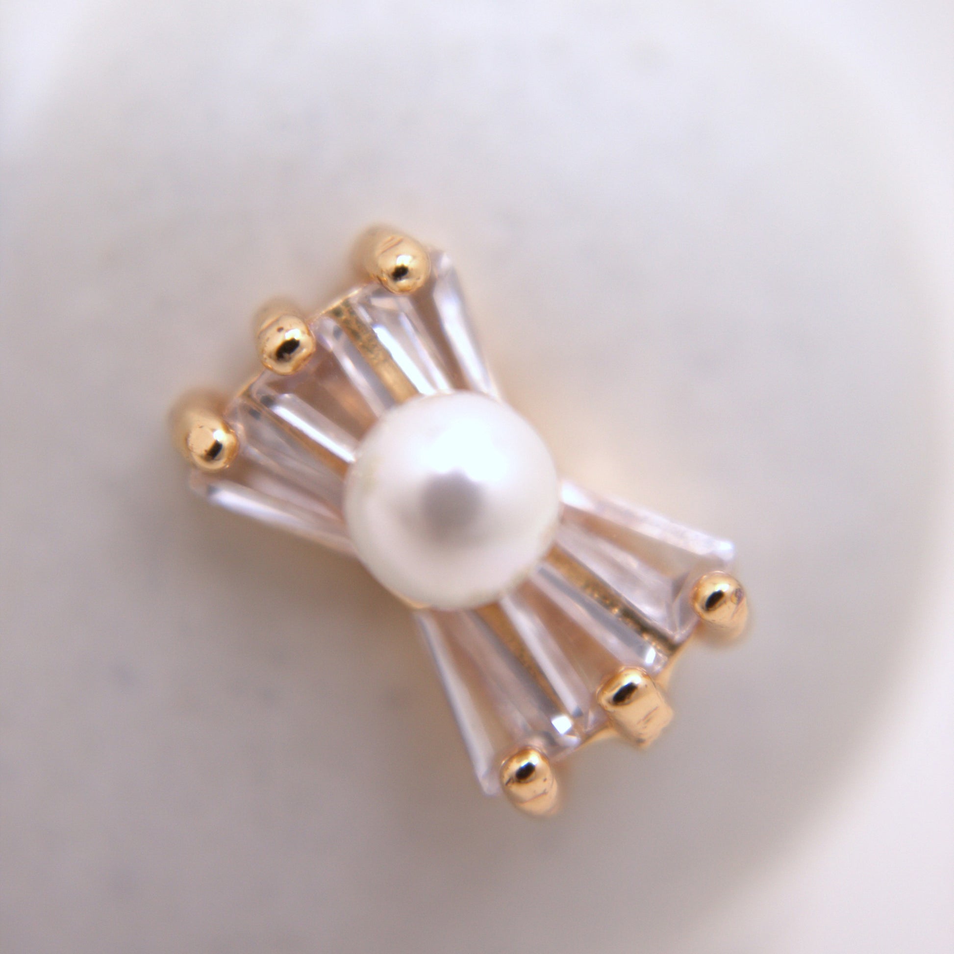Pearl brooch with gold accents on a white background