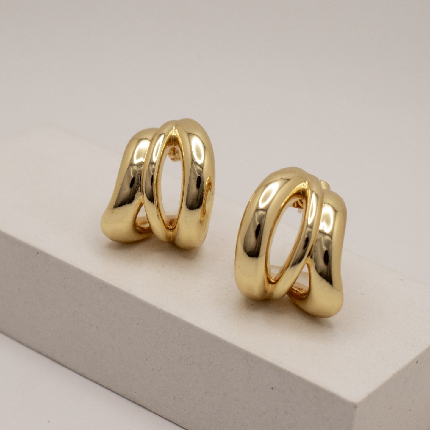 Pair of gold hoop earrings on a light gray background