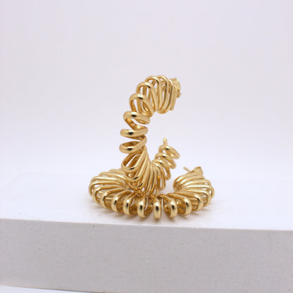 Gold spiral earring on a white background