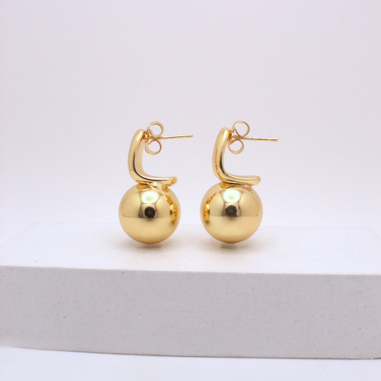 Pair of gold hoop earrings on a white background