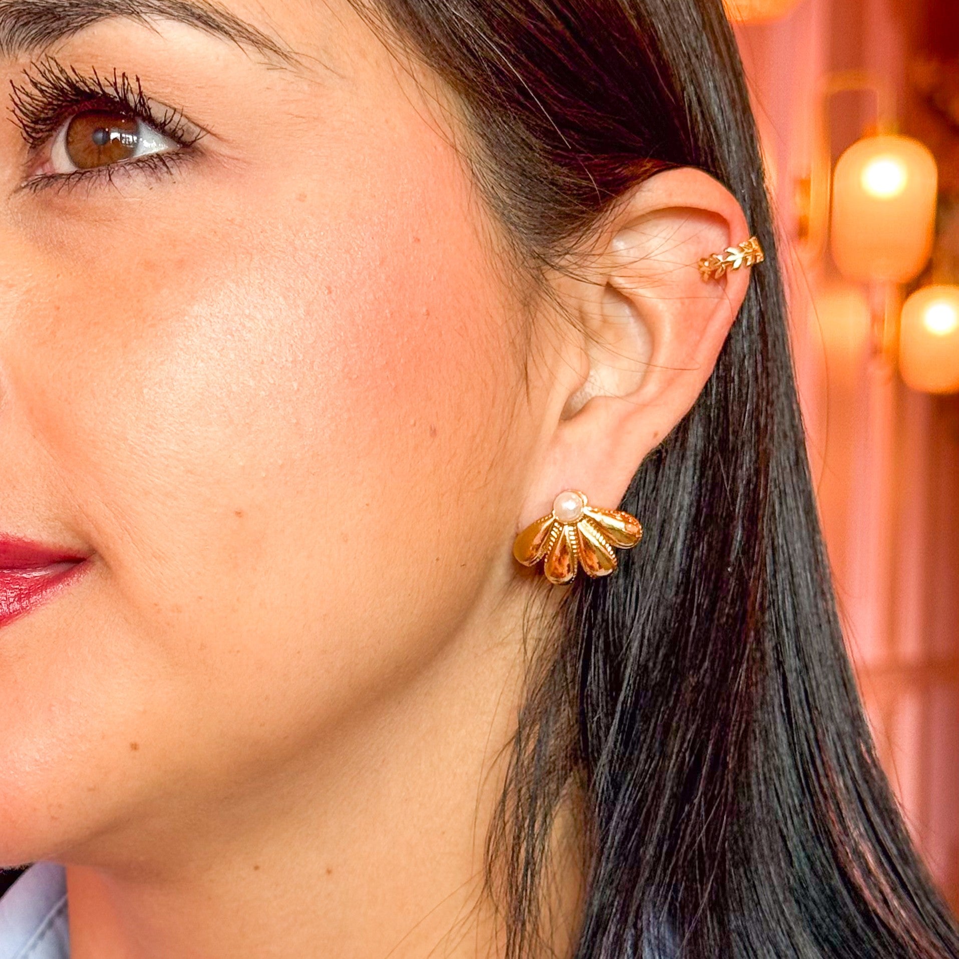 Close-up of a woman wearing gold earrings with a blurred background