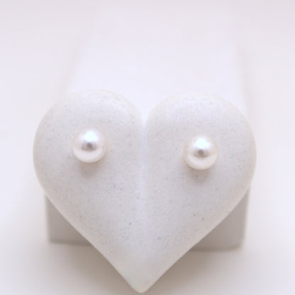 Pearl earrings on a heart-shaped white stand