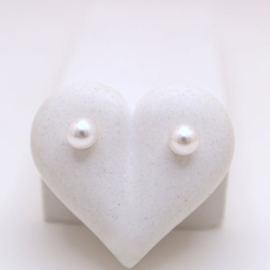 Pearl earrings on a heart-shaped white stand