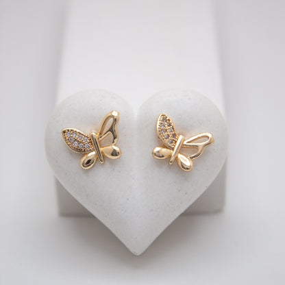 Gold butterfly earrings on a heart-shaped white stand