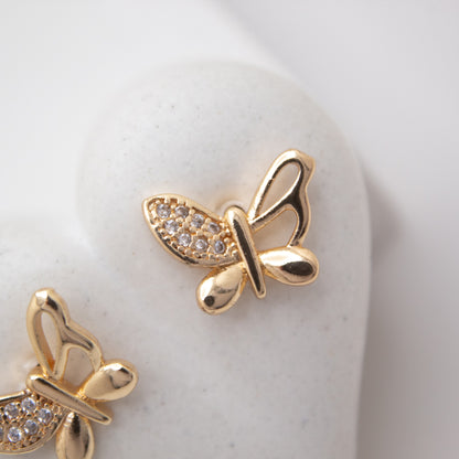 Gold butterfly earrings with gemstones on a white background