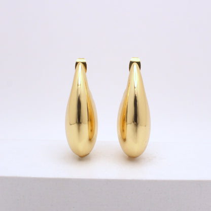 Pair of gold teardrop-shaped earrings on a white background