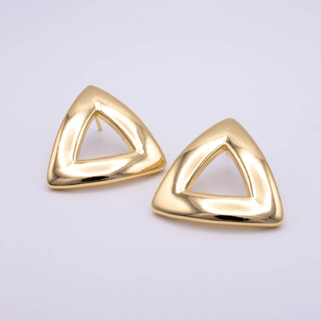 A pair of gold triangular stud earrings with an open center design, displayed on a clean light gray background.
