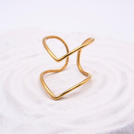 Open sculptural gold ring with flowing curved lines.