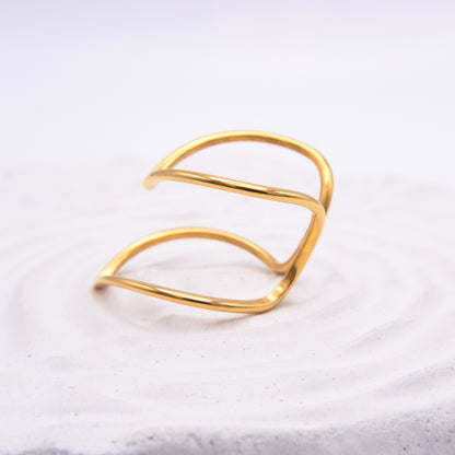 Open sculptural gold ring with flowing curved lines.