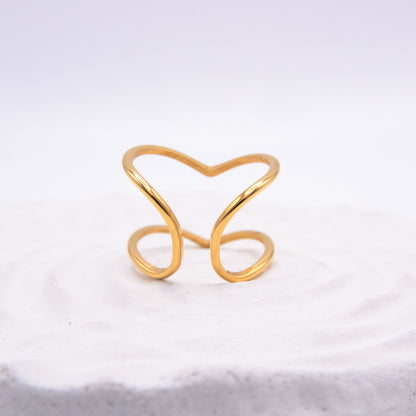 Open sculptural gold ring with flowing curved lines.