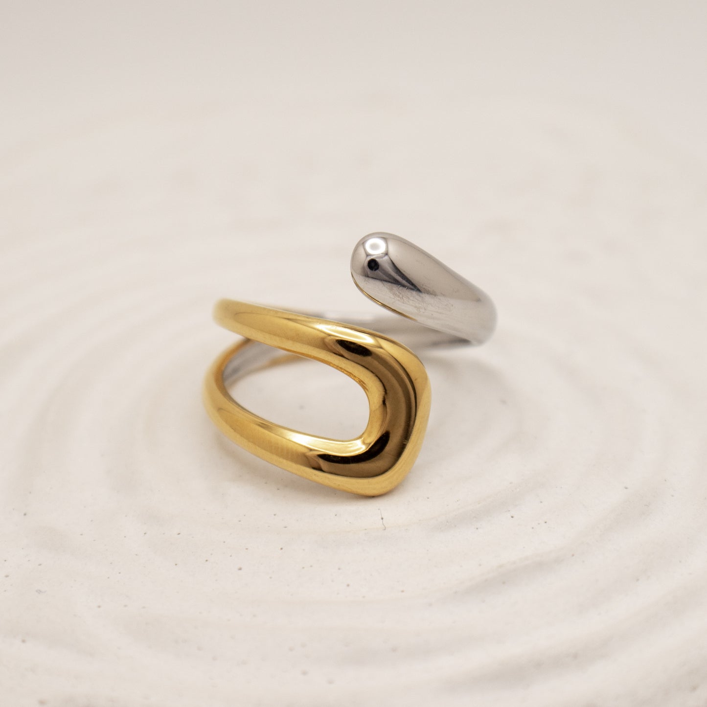 Gold and silver ring on a beige background