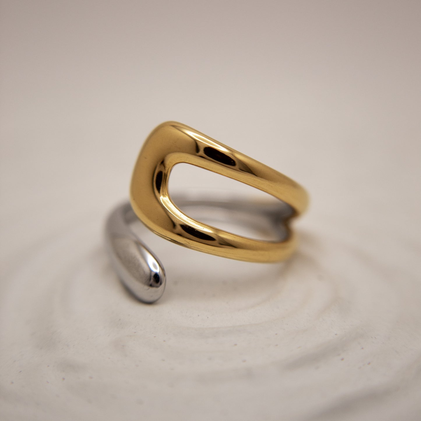 Gold and silver ring on a beige background