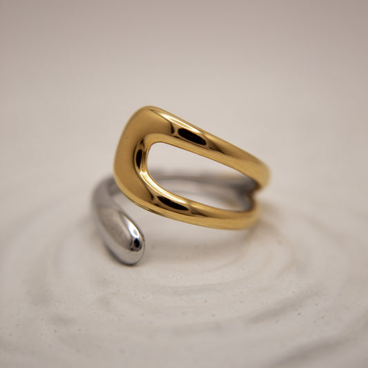 Gold and silver ring on a beige background