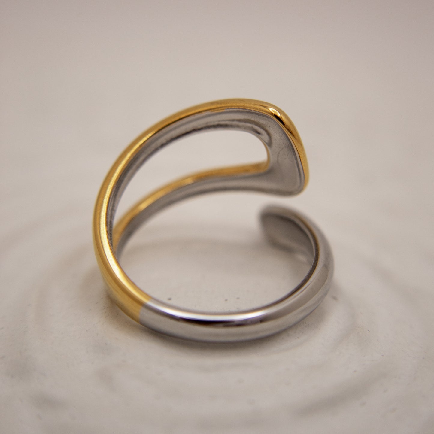 Two-toned gold and silver ring on a light gray background