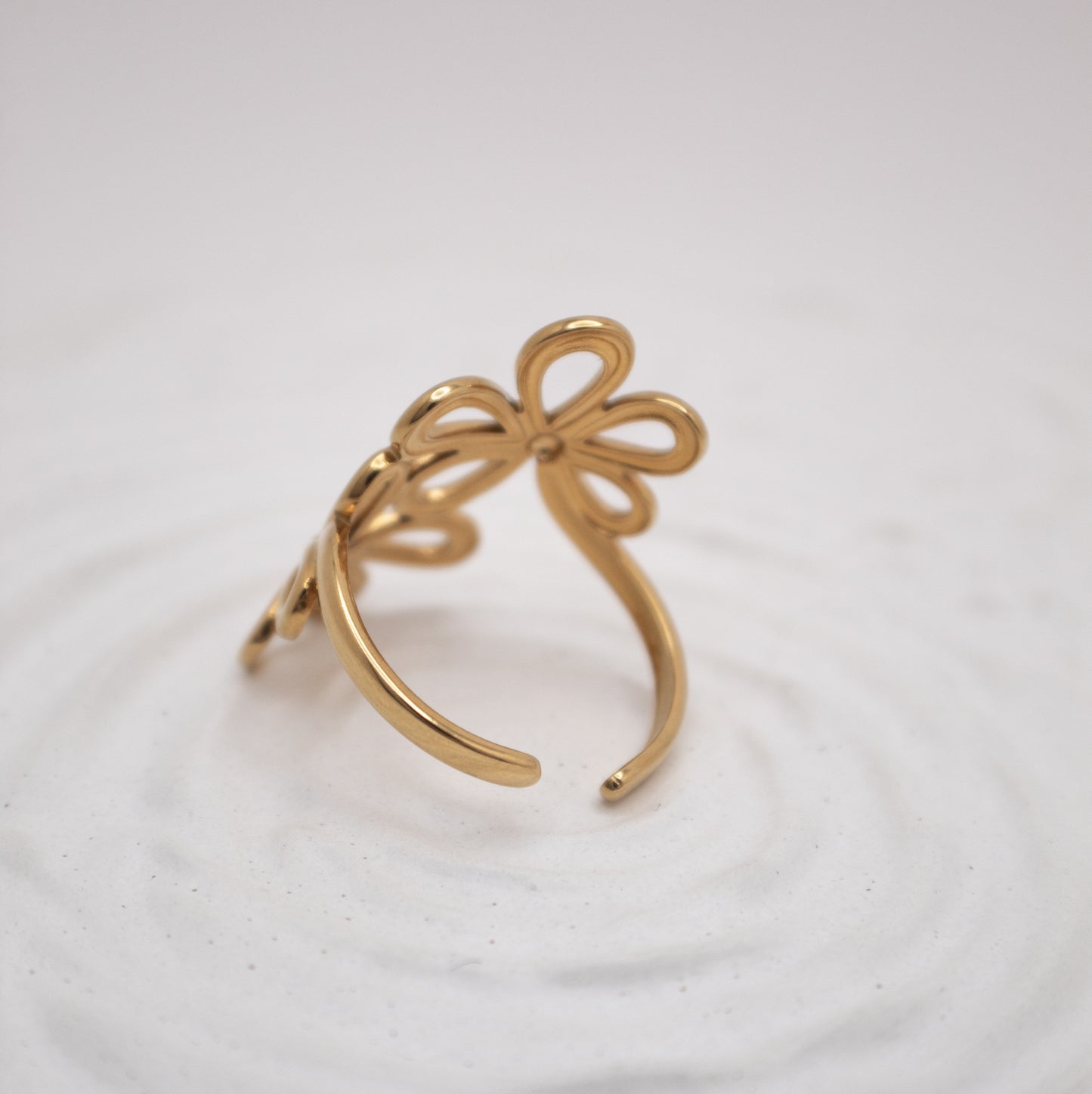 Gold bow-shaped ring on a white background