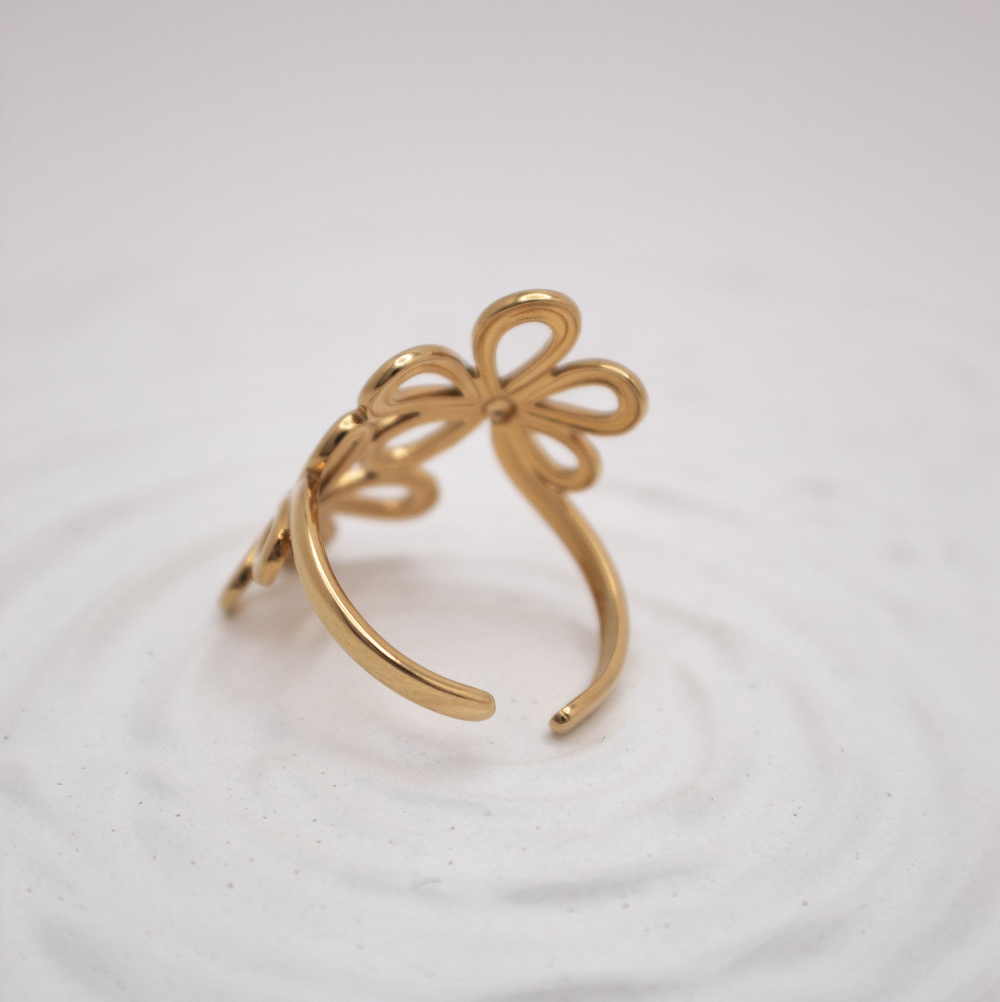 Gold bow-shaped ring on a white background