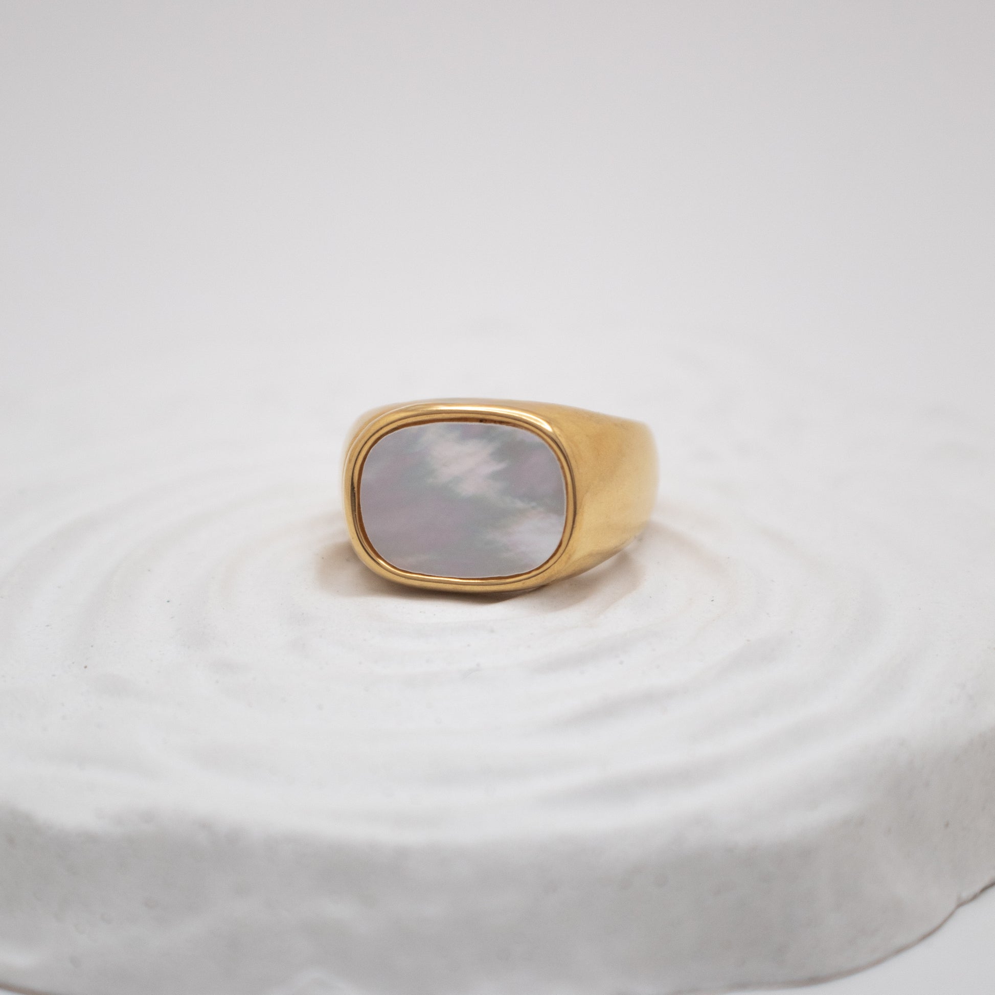 Gold ring with a stone on a white background