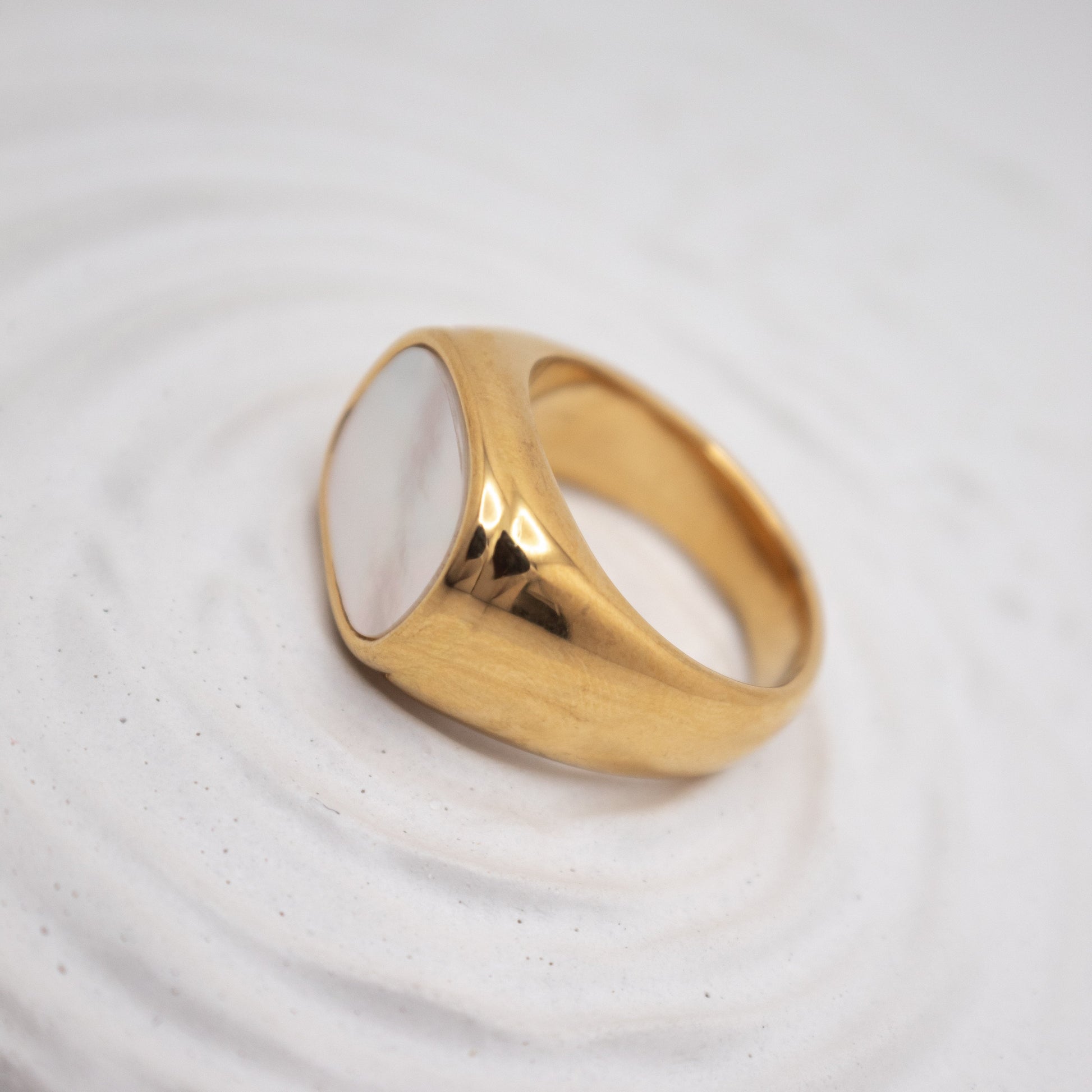 Gold ring on a textured white surface
