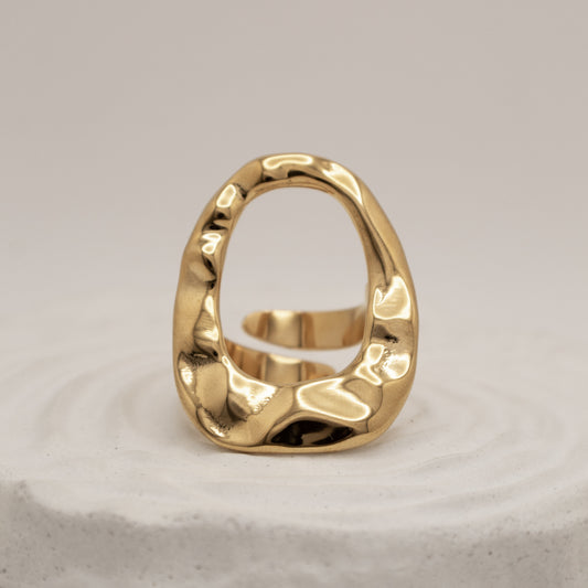 Gold ring with a textured design on a light gray background