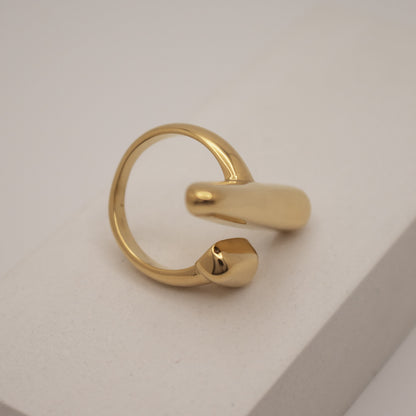 Gold ring with a unique design on a light gray background