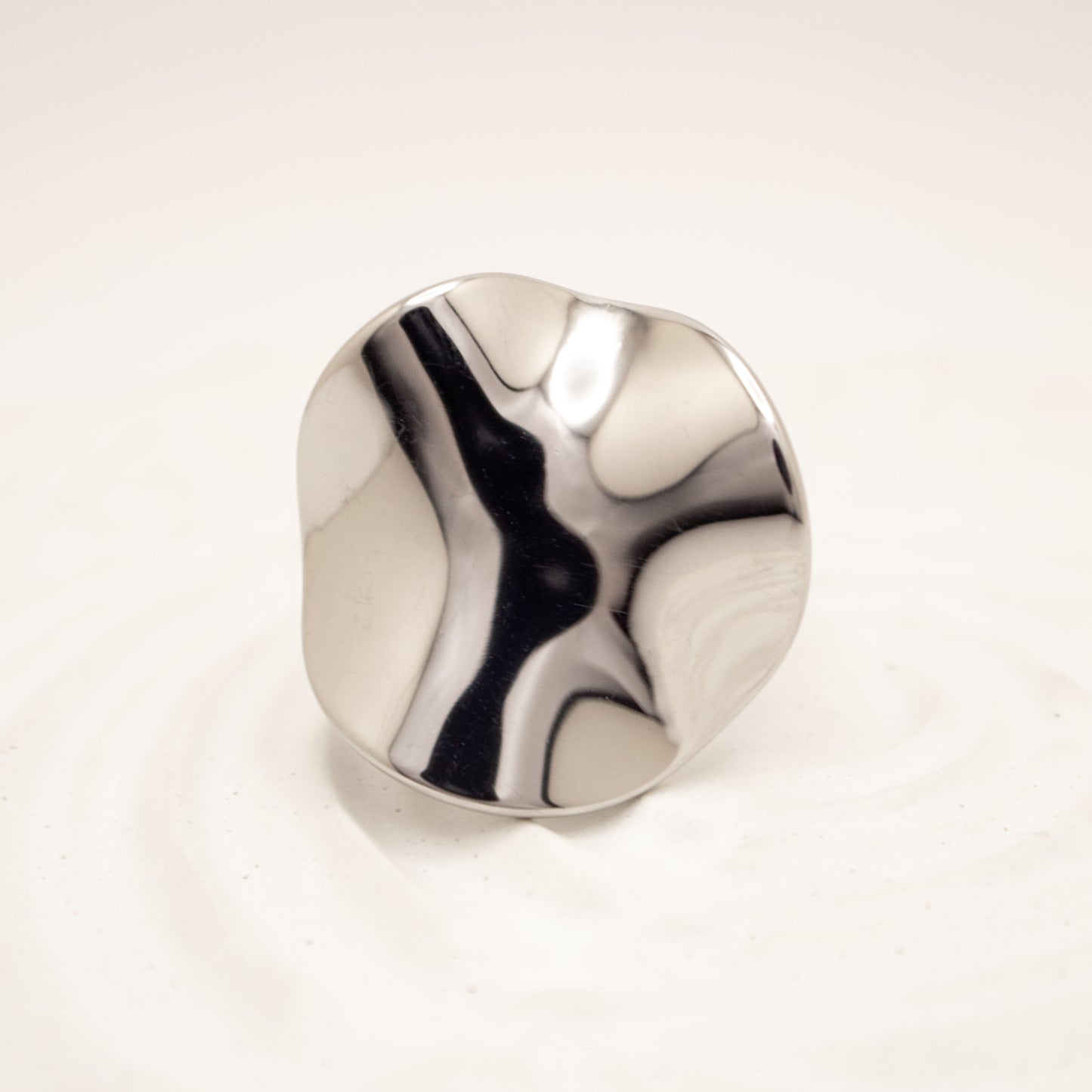 Silver ring with a marbled design on a white background