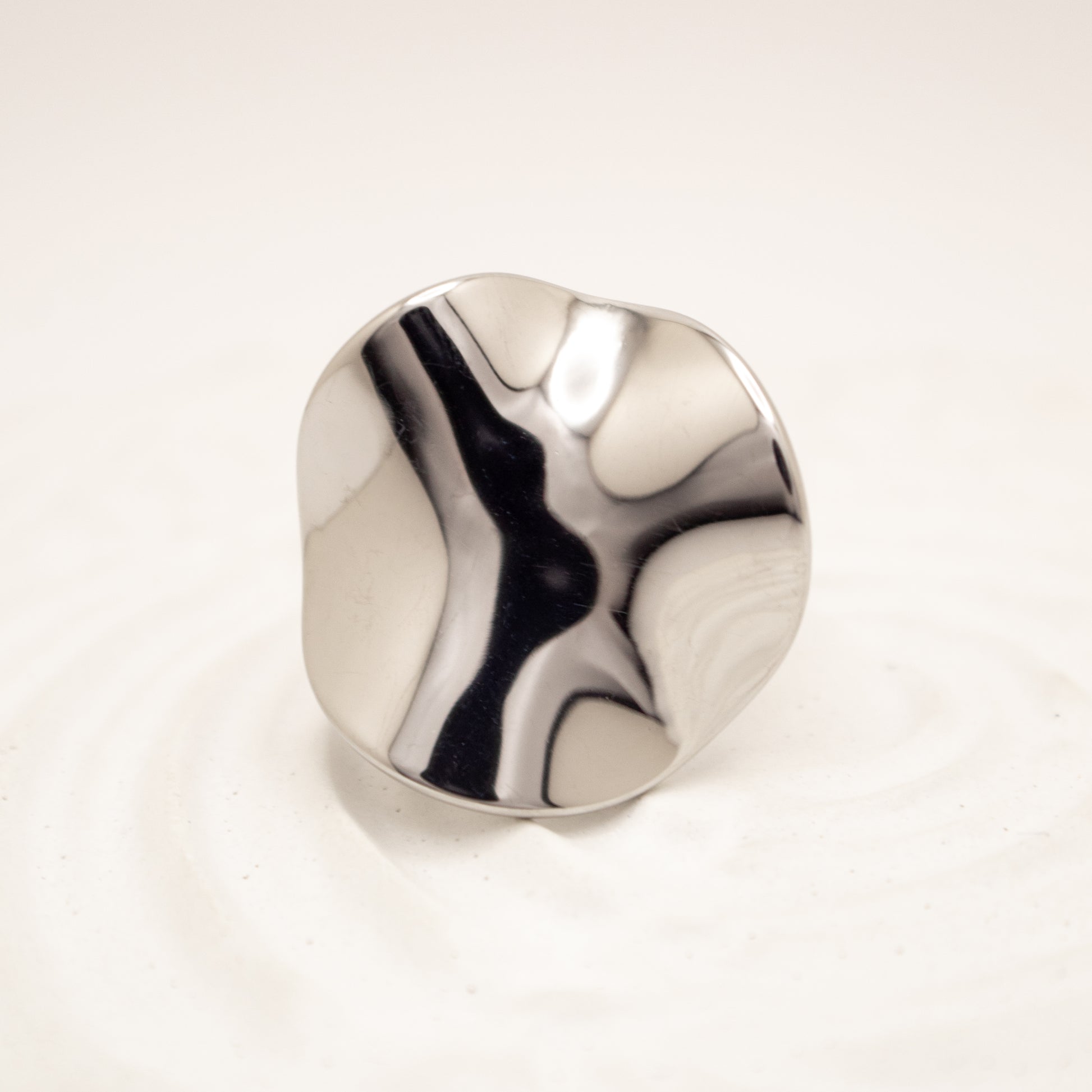 Silver ring with a marbled design on a white background