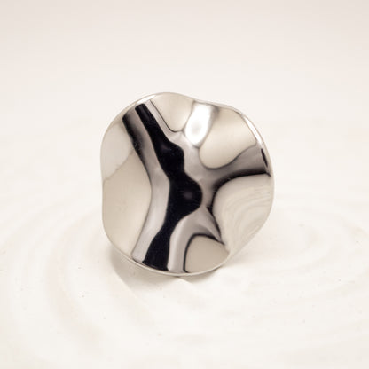 Silver ring with a marbled design on a white background