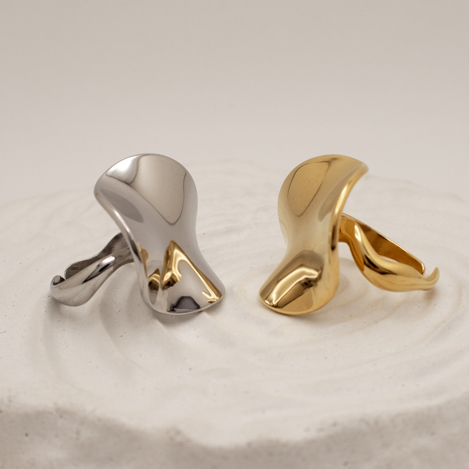 Gold and silver rings a textured beige surface