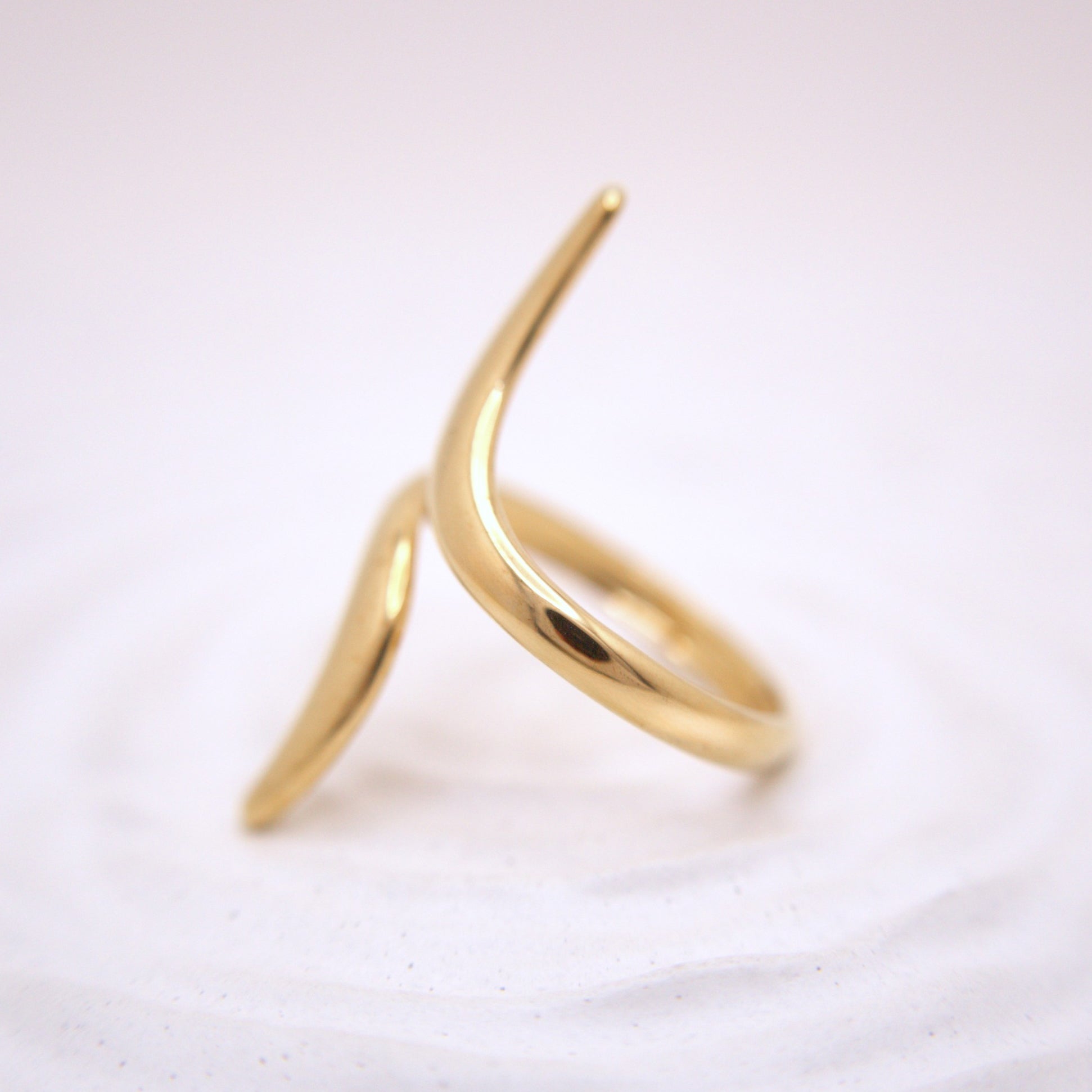 Gold ring with a unique design on a white background
