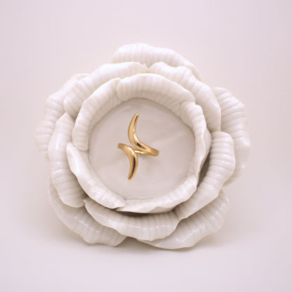 Gold ring on a white ceramic dish shaped like a flower