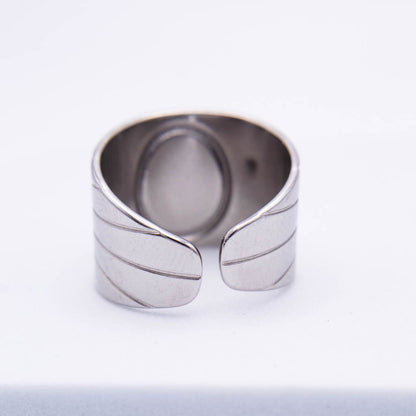 A silver-toned open band ring with a textured, ribbed leaf-like design on the exterior, photographed on a clean white background.