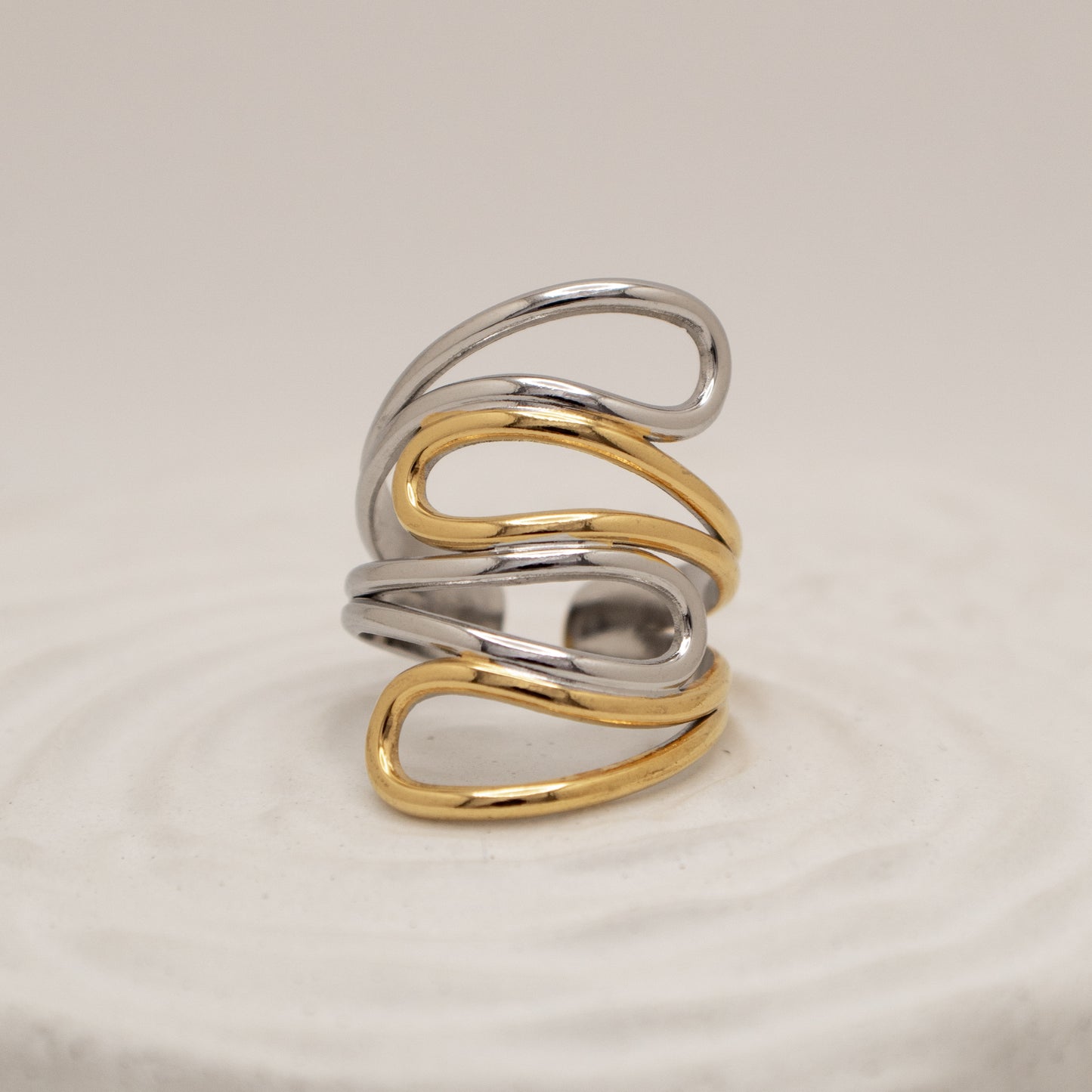 Two-toned silver and gold ring on a beige background