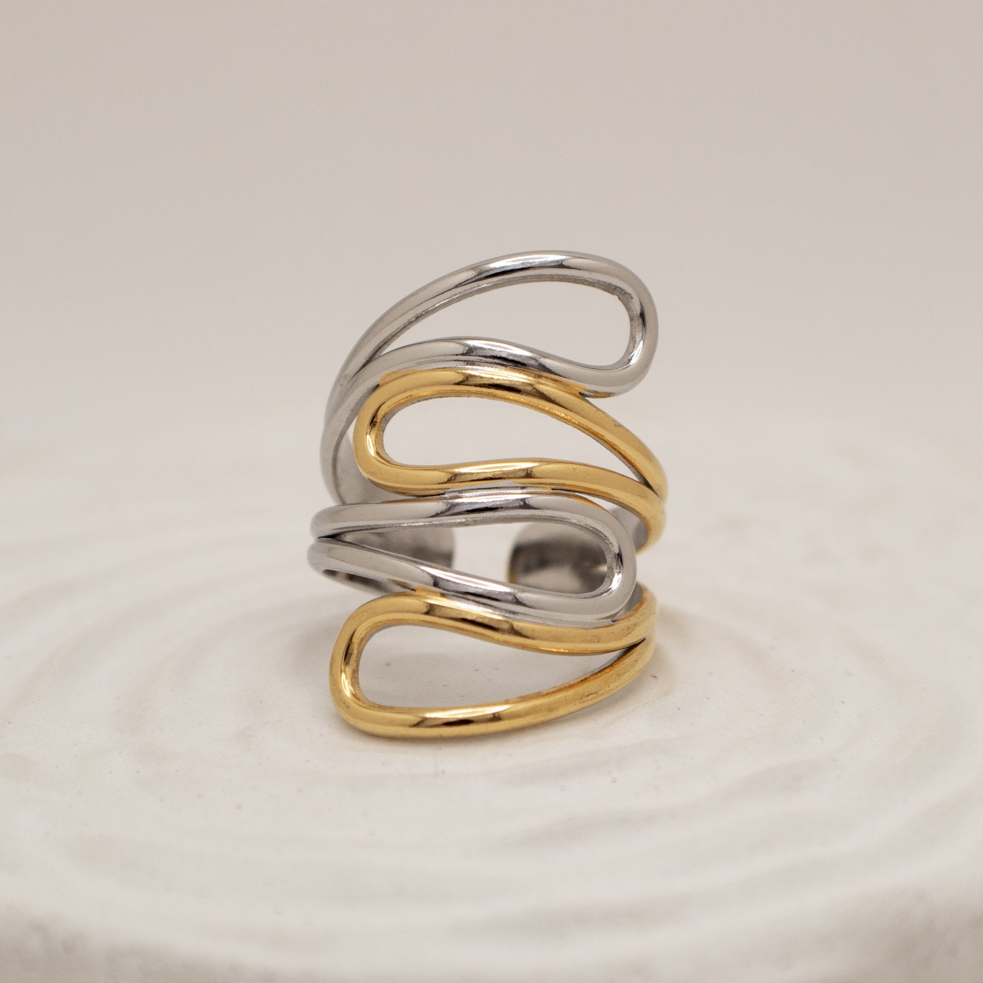 Two-toned silver and gold ring on a beige background