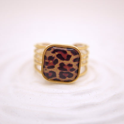 Gold ring with a leopard print stone on a white background