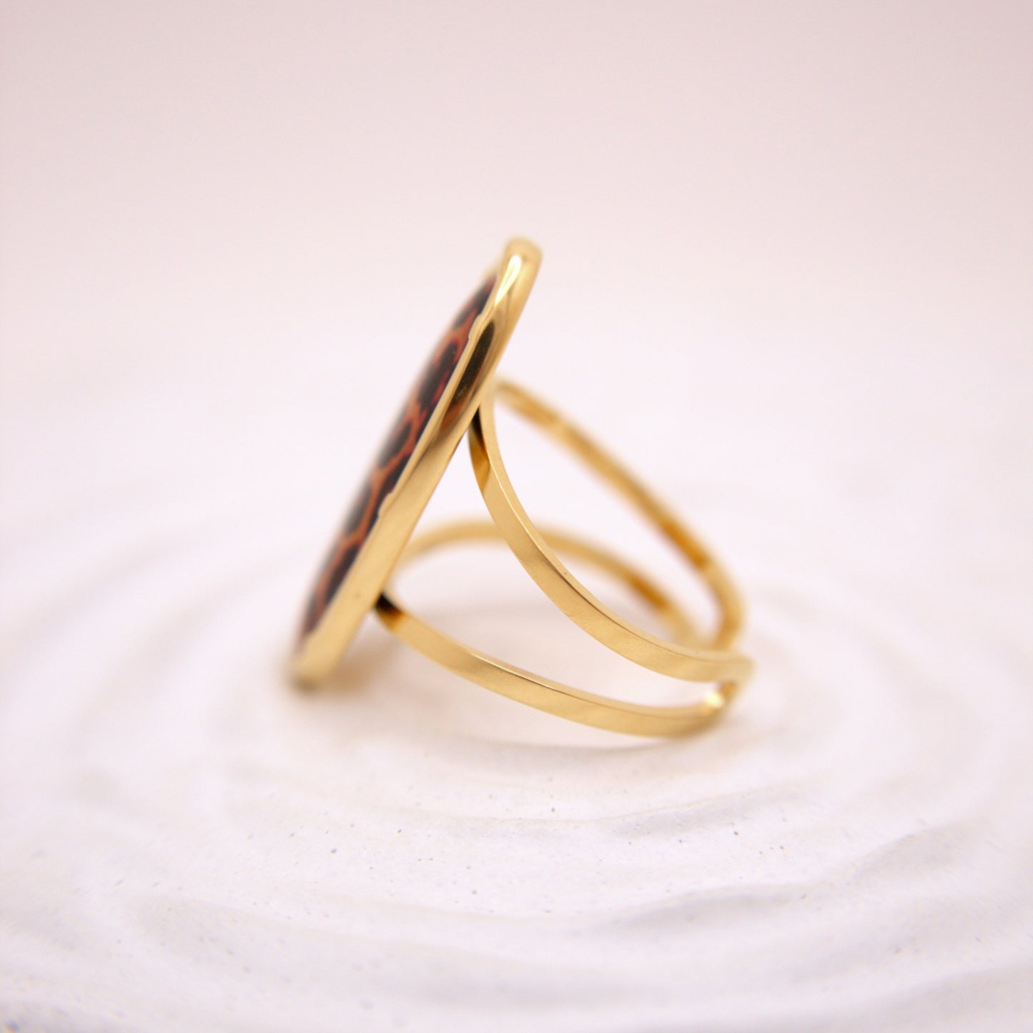 Gold ring with a circular design on a white background