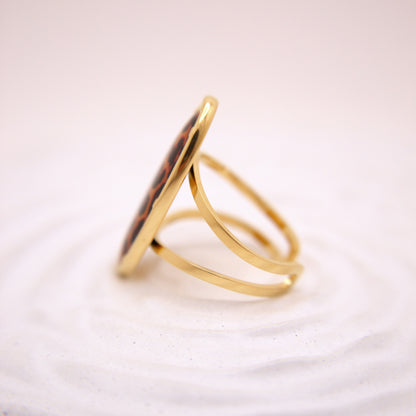 Gold ring with a circular design on a white background