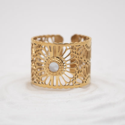 Gold cuff bracelet with intricate design on a white background