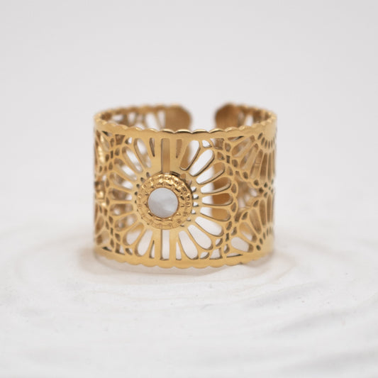 Gold cuff bracelet with intricate design on a white background