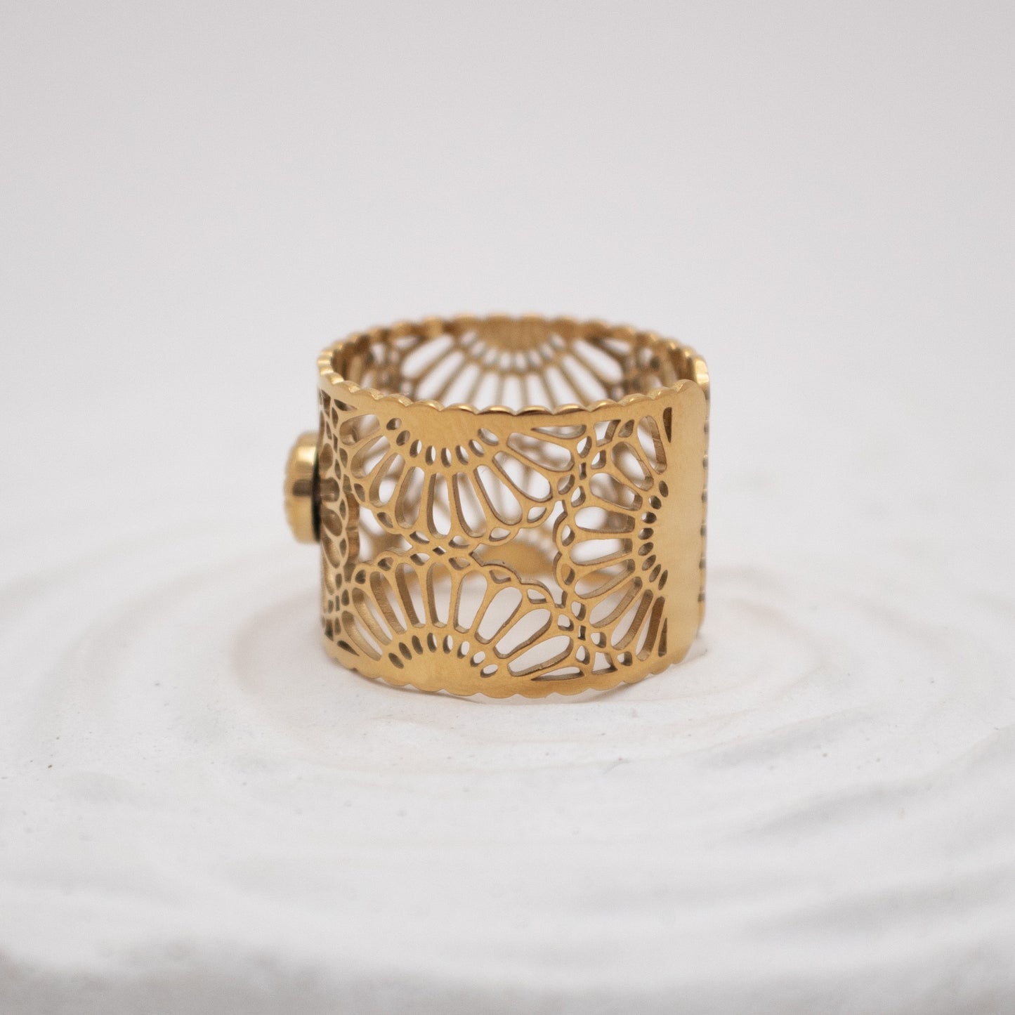 Gold bracelet with intricate design on a white background