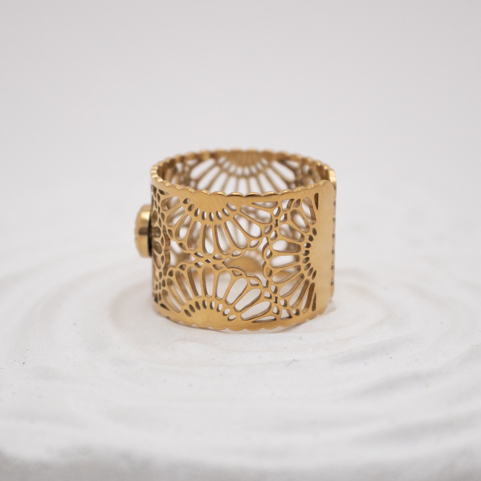 Gold bracelet with intricate design on a white background