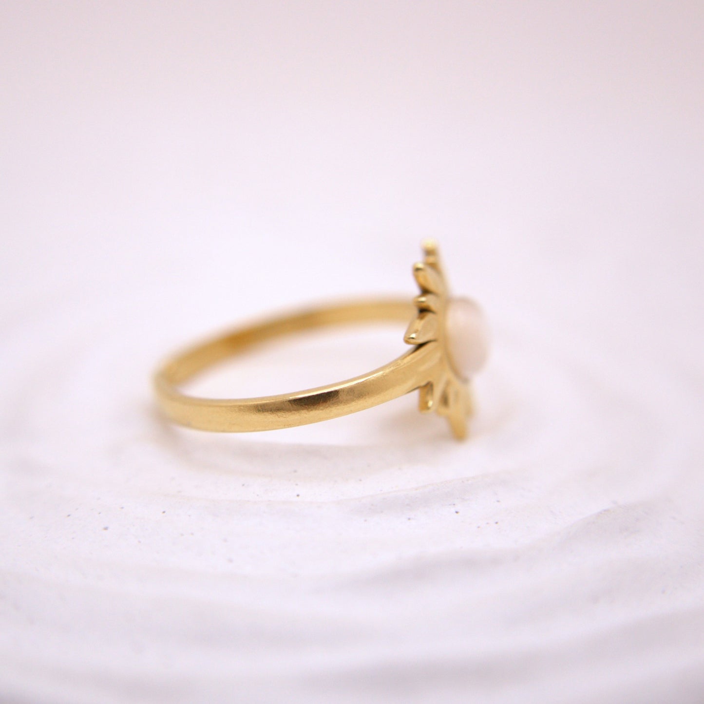 Gold ring with a small decorative element on a white background