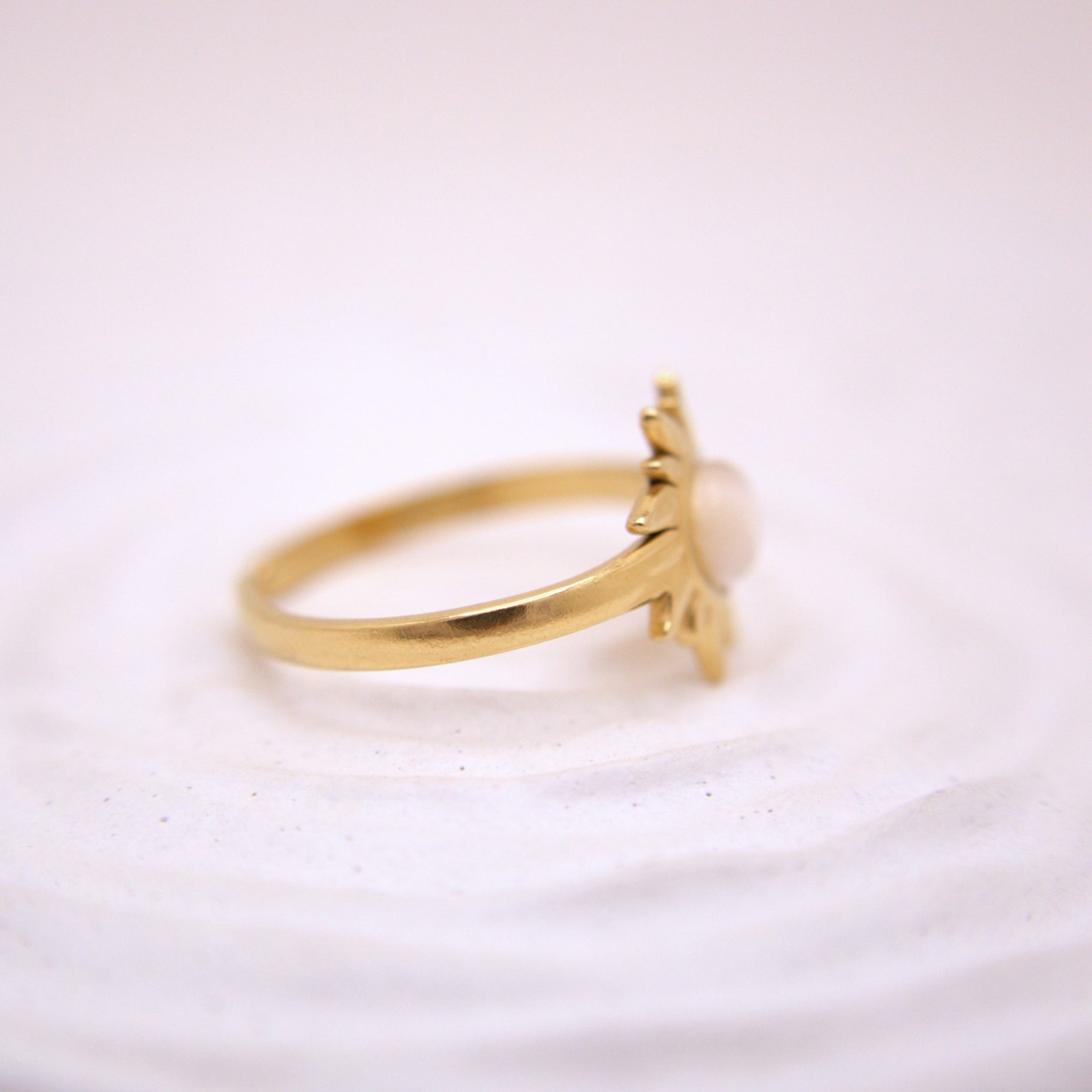 Gold ring with a small decorative element on a white background