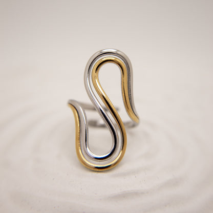Two-toned silver and gold ring on a beige background