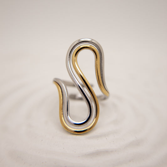 Two-toned silver and gold ring on a beige background